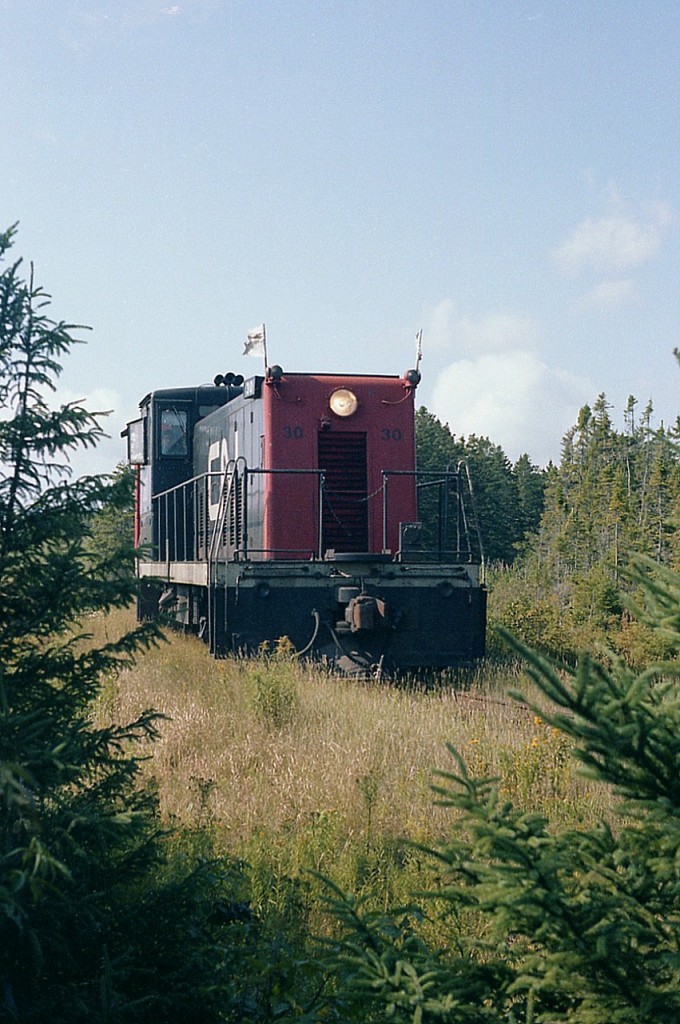 CN 30, a 70 tonner, leads a short westbound train near the hamlet of Tracadie. Yes, this IS the main line; which gives you an idea how hard it was to catch a train on it. Way back when I was lucky to catch some action as the potato harvest season was just starting up on the east end of the island. Power was 30 & 40, which handled most assignments to and from Souris. Other power on the Isle, such as a few MLW RSC-18s, worked mostly industry in and around Charlottetown, Summerside and Kensington.
