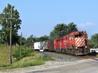 For part of May and the whole month of June, the local power out of London has had CP 3018 on it, one of 3 action red GP38's left on CP's roster. For the majority of it's time in Southern Ontario it was either facing East or was sandwiched between 2 other CP geeps. Thankfully towards the end of June the power was swapped around so that 3018 would lead West. Here we see the action red geep leaning into the curve at Drumbo on it's journey West back to London. 