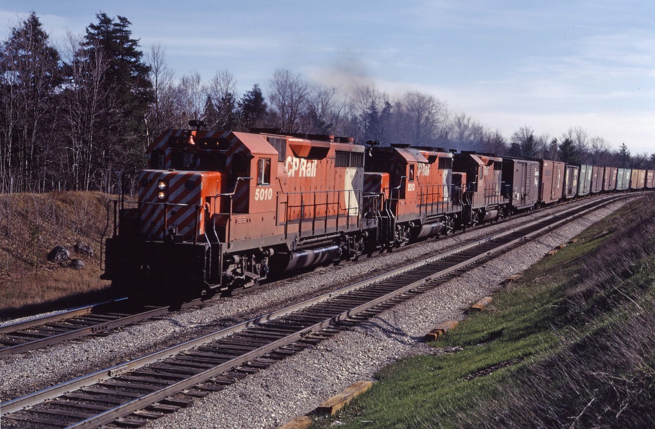 Three GP35s climb the Niagara Escarpment at Milton with a westbound in the spring of 1973.