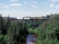 Looking roughly north-east from the Hwy 11 bridge as an ONR train powered by 1733 and 1734 heads southward; destination North Bay, on a pleasant afternoon. Way down below is the Englehart River. Both SD40-2s are still on the ONR roster.