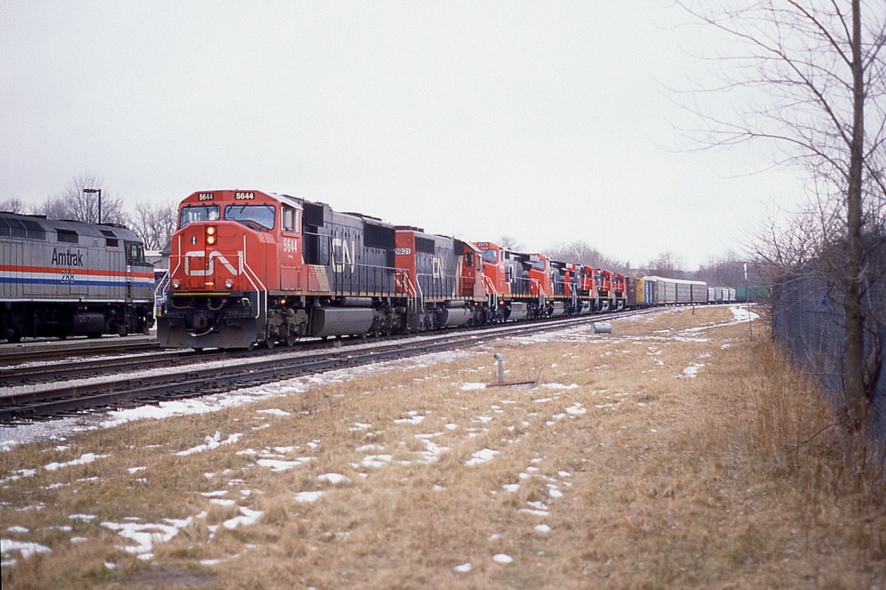 It was unusual to see a train so long that it had to pull up almost alongside the Niagara Falls VIA station in an attempt to set off cars in the CN yard. The train, out of Fort Erie, consisted of CN 5644, 5931(GT) plus new Dash-9s, 2575, 2574, 2577, 2579 and 2578 as part of an 11,500 ft train; one of the longest in Niagara we had heard of around this time. This involved a lot of running around to get the pictures.:o)
Amtrak #288 as train #98 happened to be at the station as well. This helped with the photo time and location.