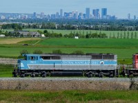 The City of Calgary in the distance does not belong to either Maine or Quebec, yet we see Central Maine and Quebec SD40-2F 9021 heading towards it with a loaded ballast train in tow. 2020 - you're crazy.