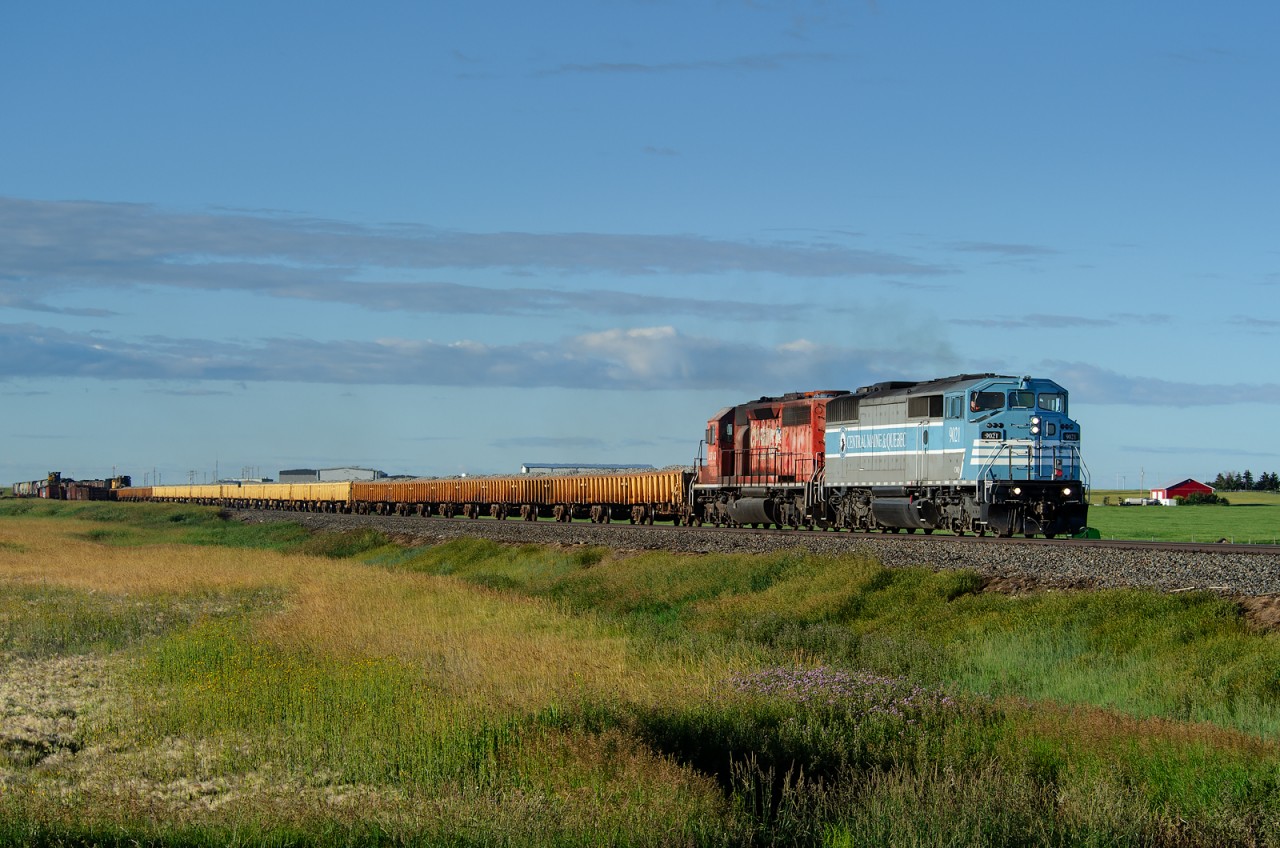 Ballast loads from Swansea, BC gather speed through Nobleford behind a very unlikely lead unit!