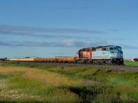Ballast loads from Swansea, BC gather speed through Nobleford behind a very unlikely lead unit!
