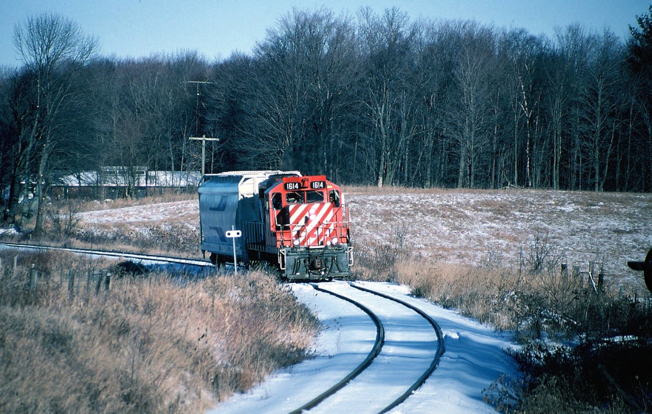 In 1997 Canadian Pacific had advised it's intention of no longer operating the Guelph Junction Railway due to continued declining traffic volumes and issued their notice of discontinuance on the Goderich Subdivision at the end of 1997. This left the city of Guelph with having no choice but to find a new operator for the following year. The last day of 1997 was sunny however it was extremely cold. If polar vortex's would have existed then that day could have been one on it's own. However the weather didn't stop history from happening as the CP Guelph local went about its regular duties. The job switched around Guelph Jct. then made a run over to Puslinch to service the customer there before returning to Guelph Jct. After some additional work the crew lifted one hopper car for Owens Corning. There CP GP9u 1614 departed for the final time for Guelph during the mid-afternoon. Here northbound 1614 is seen approaching Concession 11 at "Danger Bell Crossing" in Puslinch Township as it slowly made its way to Guelph.