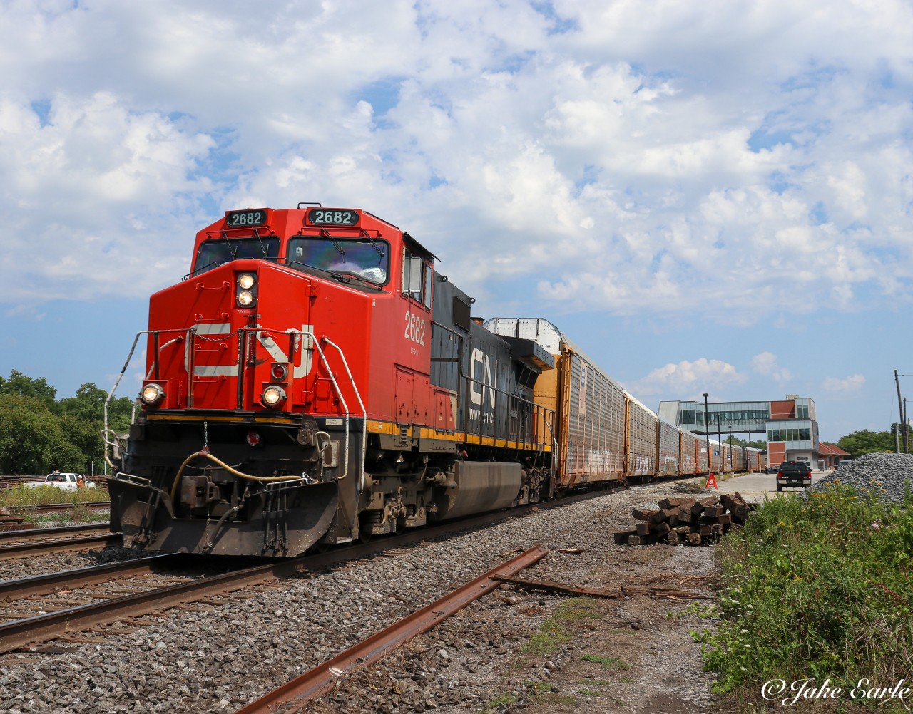 A solo Dash944CW (2682) is seen coming slowly past Cobourg station on a hot Saturday afternoon, hauling auto rack empties destined for Michigan.