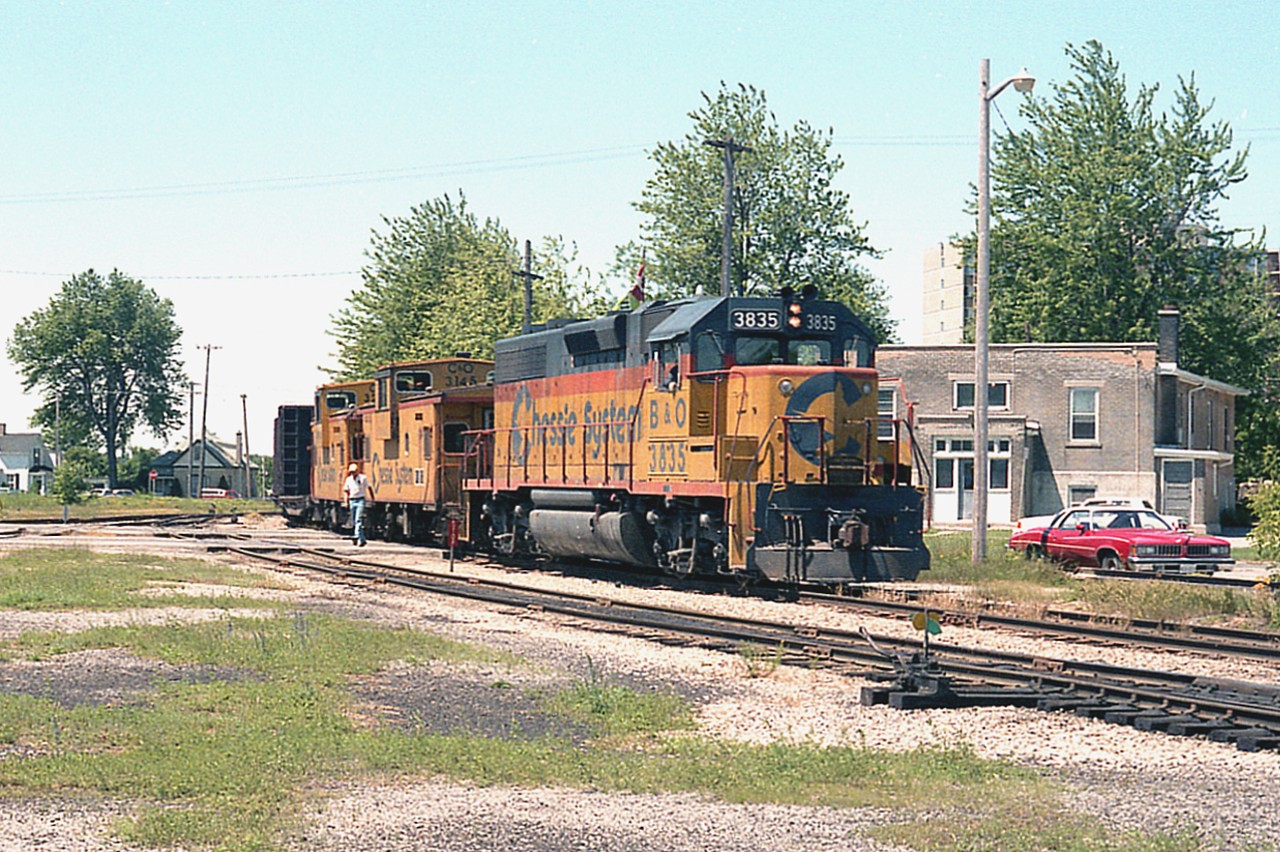 While puttering around at the Chessie facility I just happened to look back over behind me and there was B&O 3835 and a couple of vans in tow; a local working back to the yard. The scene show the train crossing Elm St near Wilson, entering the yard property. Like many of the photographers, I really miss this place.
