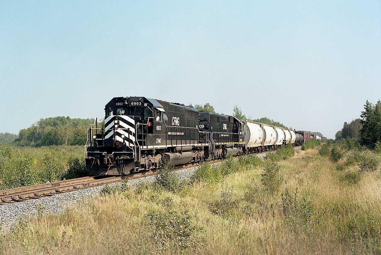 Try as I may, I just could not quite pin-point the location of this shot. So, took a stab at it. Belledune.
The Matapedia & Gulf Railway was only in business under this name from 1998 to 2008. On Nov 3, 2008, CN purchased NBEC (New Brunswick East Coast) and the CFMG as well as the Ottawa Central in Ontario and a small road at Matane, Quebec from the Quebec Railway Corporation and that was it for the CFMG.
Second unit behind 6903 is 6909. These SD40s were previously CN 5057 and 5070, acquired in 1999.