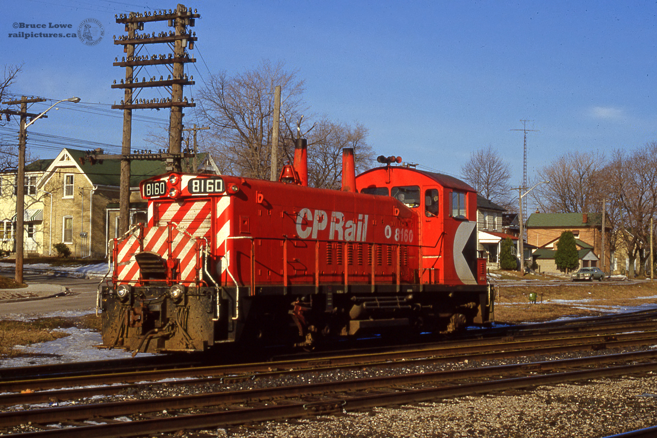 Nearing the end of a late winter's day, CP 8160 pauses during switching assignments at the west end of Galt Yard.  8160, along with two other GMD SW1200 units; 8161, 8162, were the regularly assigned power on the Grand River Railway/Lake Erie & Northern lines of Canadian Pacific, based out of the 1907 Preston Shops.  Note the striped plywood covering affixed to the front handrails, protection against snow entering the radiator shutters.  The 8160 would wear the Multimark paint scheme until 1989, when it would receive a new coat of Action Red sans Multimark.  The unit never made it into the 1200-series rebuild program, having suffered an electrical fire in 1992, it would be scrapped in 1993.
