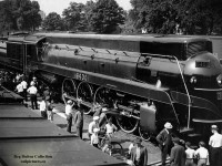 Newly built CNR 6400, one of <a href=https://ingeniumcanada.org/sites/default/files/styles/large_1/public/2019-04/artifact-1967-0001-steam-locomotive-canadian-national-cstmc-garth-wilson-gallery3.jpg?itok=mloBwA68>five</a> U-4-a 4-8-4 locomotives built by MLW in 1936, is seen on public display at the Ferguson Avenue freight shed in Hamilton.  The streamlined Confederations were used in Ontario/Quebec passenger service until their retirements in 1960/1961.  CN 6400 is the sole survivor of the fleet, currently <a href=https://ingeniumcanada.org/sites/default/files/2019-04/artifact-1967-0001-steam-locomotive-canadian-national-cstmc-garth-wilson.jpg>on display</a> at the Canada Science & Technology Museum along with various other pieces of railway equipment.  Shortly after construction it was used as an excursion locomotive out of Laprairie, Quebec in 1936 for the <a href=https://scontent-yyz1-1.xx.fbcdn.net/v/t1.0-9/37379697_10156178577470081_7816192308025491456_o.jpg?_nc_cat=111&_nc_sid=730e14&_nc_ohc=lgDdPf5yMigAX9d-HOG&_nc_ht=scontent-yyz1-1.xx&oh=b797c68ea7bd78b02e14a72e9a34a05a&oe=5F65AAF3>centennial celebrations</a> of Canada's first railway; the Champlain & St. Lawrence, having commenced operation on July 21, 1836 with locomotive <a href=https://media.gettyimages.com/photos/the-dorchester-canadas-first-locomotive-pictured-alongside-the-worlds-picture-id530797626?s=2048x2048>Dorchester</a> built in England at Newcastle upon Tyne.  6400 would shed it's olive green paint for <a href=https://www.steamlocomotive.com/whyte/4-8-4/Canada/photos/6400.jpg>Royal Blue</a> as it and <a href=https://www.themetrains.com/royal-train-main.htm>six other Canadian locomotives</a> would pull the Royal Train carrying <a href=https://ingeniumcanada.org/sites/default/files/styles/large_1/public/2019-05/6400-locomotive-with-king-george-vi-and-queen-elizabeth.jpg?itok=GHz_d93e>King George VI, Queen Elizabeth II,</a> throughout Canada in May and June, 1939 in what would be the first visit to Canada by reigning Monarchs.  1939 would also see 6400 still in royal blue make a trip to New York as an exhibit in the <a href=https://pbs.twimg.com/media/Brnm0YIIUAAfpk_?format=jpg&name=medium>"World of Tomorrow"</a> display at the New York World's Fair.  After just over two decades in service, 6400 would be retired in 1960, ending up in a scrap line at the <a href=http://www.rrpicturearchives.net/showPicture.aspx?id=595333>London Reclamation Yard</a> before being set aside by CNR for preservation as part of the Museum Train; also known as the <a href=http://bp1.blogger.com/_IPZX1n_gnIM/SEdWP4gl4PI/AAAAAAAABYY/fEfpBFZcQ_U/s1600-h/Journey-into-yesterday.jpg>"Journey into Yesterday".</a>  It would continue in museum train service as well as appearing at other event displays until Canada's centennial celebrations in 1967, when the Museum of Science and Technology in Ottawa would open.  6400 and a number of other locomotives were <a href=https://churcher.crcml.org/Circle_Articles/Article_Meldrum04.html>pushed inside</a> for permanent display.<br><br>The CNR <a href=http://www.oil-electric.com/2008/06/museum-train-part-1.html>Museum Train</a> began in 1953 with CN 40, a 4-4-0 built for the Grand Trunk in 1872, CN 247, a saddle tank 0-6-0 built in 1894 for Grand Trunk, and CN 713, a 2-6-0 built for Grand Trunk in 1900 and a selection of vintage wooden equipment dating as far back as 1859.  The train toured Canada highlighting railway heritage and the railway's contributions to the country until 1967, Canada's Centennial, when the National museum of Science and Technology opened in Ottawa.  The Museum train was retired and put on display.<br><br>CNR's Ferguson Avenue <a href=https://scontent-yyz1-1.xx.fbcdn.net/v/t1.15752-0/p280x280/95878341_644542212762572_3479923214937751552_n.jpg?_nc_cat=103&_nc_sid=b96e70&_nc_ohc=u08wjgp-oJsAX_a0L8T&_nc_ht=scontent-yyz1-1.xx&_nc_tp=6&oh=aac29706746730fc76e53a8b17edac59&oe=5F67C41E>freight sheds,</a> the sixth largest in Canada, stretched north-south from Barton Street south to Canon Street.  One of the customers using the shed was <a href=https://www.ontariolantern.ca/tubular-lanterns/e-t-wright-co/>E.T. Wright & Co.,</a> a tinware company eventually manufacturing many types of lanterns, including for use by <a href=https://www.ontariolantern.ca/railway-other/railway-lanterns/>Canadian railways.</a> From the small yard beside the shed, switchers could run over to the N&NW spur without crossing the Grimsby Sub by using an underpass of Barton Street and the Grimsby, reconnecting to the N&NW spur around the intersection of Wellington Street North and Simcoe Street East.<br><br>Through the trees at upper left the addition to the <a href=https://www.thesil.ca/wp-content/uploads/2017/02/royal.jpg>Royal Connaught Hotel</a> can be seen at the corner of King Street East and John Street South.  The Royal Connaught, built in 1914-1916 by Pigott Construction, and named after then Governer General of Canada, Prince Arthur, Duke of Connaught (and Strathearn,) has stood for over 100 years, now serving as the Residences of the Royal Connaught Condominiums after the hotel closed in 2008.  This hotel would not be the only structure named after the Governer General, as the Canadian Pacific Railway's 5.02 mile long Selkirk Tunnel on the Roger's Pass line in British Columbia, opened by the Duke of Connaught in 1916, would be renamed the <a href=http://www.trainweb.org/oldtimetrains/CPR/Connaught_Tunnel.jpg>Connaught Tunnel</a> a few weeks later after opening.