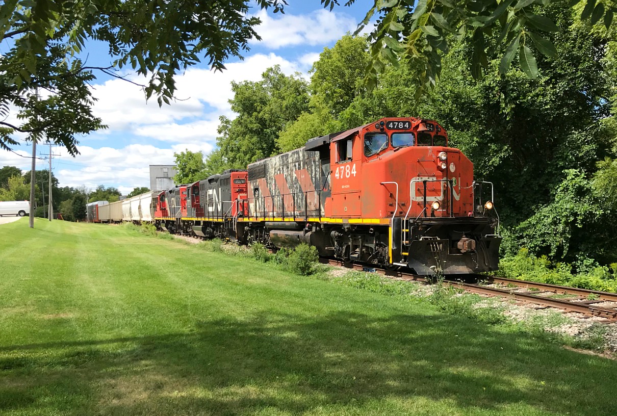 CN L568 with 4784, 7071 and 7083 is crossing Queen Street in Kitchener, Ontario on the Huron Park Spur as it heads to the interchange with Canadian Pacific. After working the spur, L568 would depart westbound for Stratford on the Guelph Subdivision. August 24, 2019.