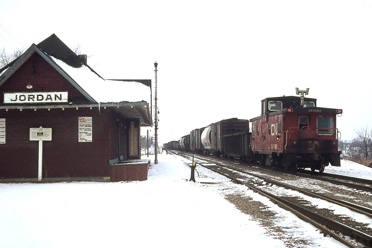 Well, it was fun while it lasted. All those neat little hometown stations with friendly personnel to shoot the breeze with. All over Ontario. CP Parry Sound was the best. There, Jimmie Bell was so nice to visit many trips were just so I could sit at the station.  Here, in snowbound Jordan on the CN, the operator is long gone; I am not sure what year he was removed. But I still liked it here. The building is boarded up and ended up being sold and moved a few hundred yards away where it now stands as a beautiful home. Complete with namesign. I slow down and admire it each time I pass by.
It is too bad life is so impersonal along the lines today.
Jordan was a nice place to hang out. The bridge is a few hundred feet in the distance in this photo, and soon another thing of the past, the caboose, will trundle over it and all will be quiet again. Then, it is time to go.