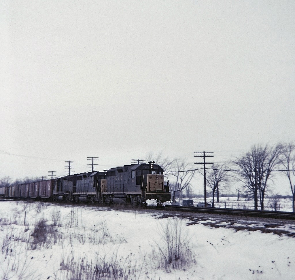 A trio of GP35's, C&O 3523,3528 & 3537 on a eastbound freight have just clattered over the diamond at Canfield Junction on the now long gone CASO sub. The C&O had running rights on this track from St.Thomas. I was about half way between the diamond and Junction Road which crosses the double track mainline. If I recall Junction Road crossing was protected with the old style "wig wag" light and of course it never occurred to me to take a picture of the wig wag arm and light. On this day, Bruce Mercer and I spent time at Canfield as well as E&O Tower further east of Canfield. 9 trains were seen this day, from 4 different railways, including TH&B at E&O.