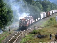 "On this day..." 19 years ago, smoke has brought some of the locals out to check on the action trackside: a freight lead by CP SW1200RS units 1271, 8161 and 8156 is stopped near Aberdeen Yard, by the site of the former TH&B Chatham Street shops as 8156 "burns up" (caught on fire) on a warm August day in 2001. The little SW1200RS units originally built in the 1950's for branchline use still held down some local and yard work, but because of their diminutive size it was common in later years to see them working in pairs or trios. By this time they were on their way out, and their numbers continued to dwindle until the last few stragglers were sold off by CP in 2013.<br><br>During its final years on CP, 1271 was the only active SW1200RS in the Toronto area, and regularly assigned to Peterborough as the local switcher there (it was sold to GMTX in 2012).<br><br><i>Bill McArthur photo, Dan Dell'Unto collection slide.</i>