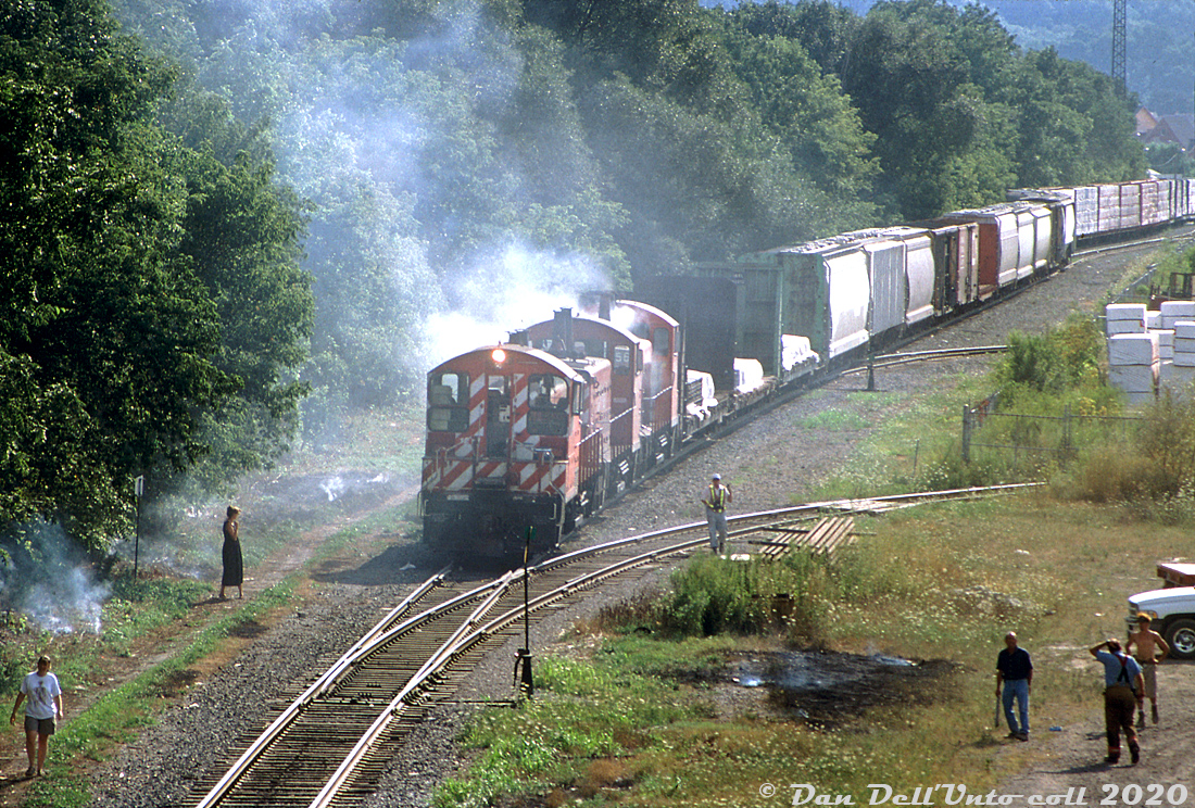 "On this day..." 19 years ago, smoke has brought some of the locals out to check on the action trackside: a freight lead by CP SW1200RS units 1271, 8161 and 8156 is stopped near Aberdeen Yard, by the site of the former TH&B Chatham Street shops as 8156 "burns up" (caught on fire) on a warm August day in 2001. The little SW1200RS units originally built in the 1950's for branchline use still held down some local and yard work, but because of their diminutive size it was common in later years to see them working in pairs or trios. By this time they were on their way out, and their numbers continued to dwindle until the last few stragglers were sold off by CP in 2013.

Bill McArthur photo, Dan Dell'Unto collection slide.