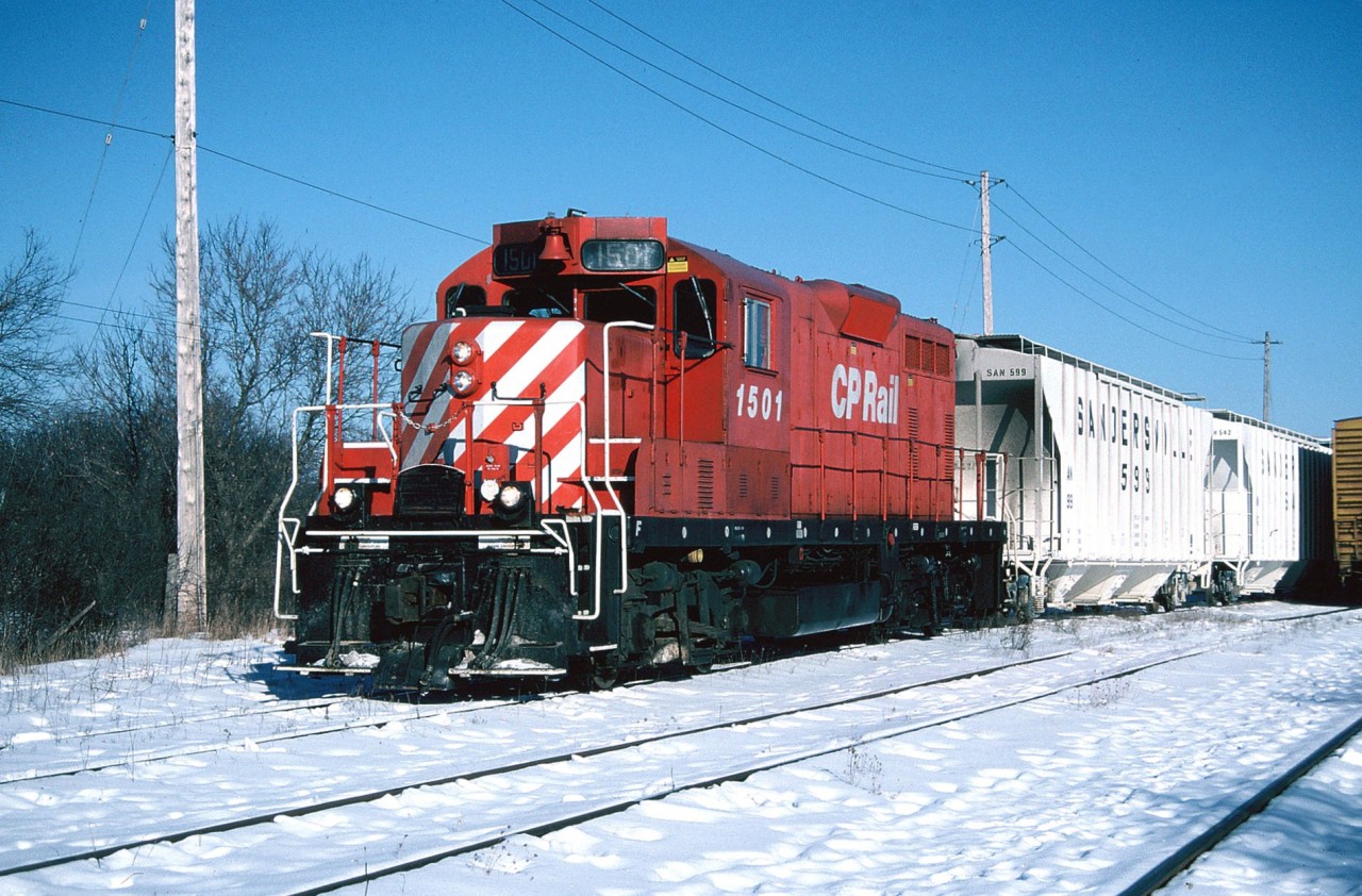 In the mid 1990’s the Guelph Junction Railway (GJR) lived a fairly quiet existence serving the city of Guelph with a Canadian Pacific local that was based out of Guelph Jct. in Campbellville.  While the Guelph to Guelph Jct. portion was owned by the city, the GJR line was operated by CP and once extended to Goderich on Lake Huron. Officially named the Goderich Subdivision, the section between Guelph and Goderich was abandoned in 1988 after the last run occurred on December 16, 1988 with GP38-2 3032. The rails between Goderich and the Guelph city limits were lifted in 1989.  

By 1994, the remaining Guelph industries that utilized rail service by GJR included; ABB, Guelph Utility Pole, W.C. Wood Company, the Guelph Co-Op, Huntsman Corporation and Owens Corning, with the latter two getting the most cars. The other customers received rail shipments infrequently and runs to the interchange with CN occurred only as needed during the week. 

The typical weekday for the CP Guelph local’s crew was to switch the small yard and the nearby lumber companies at Guelph Jct. during the morning. This occurred after all the weekly morning GO Transit sets departed eastbound for Toronto. After its work at Guelph Jct. was completed the job would depart westbound on the Galt Subdivision to Puslinch to service the transload that was situated beside the siding and mainline. Following its work here, the local would return to Guelph Jct. where the crew completed any additional switching prior to departing for Guelph if required with usually a small train. 

After arriving light power from Campbellville, here CP GP7u 1501 is seen lifting a hopper car of clay in the yard at Stevenson Street in Guelph. Soon the job would depart for the Owens Corning glass plant located along York Road on a very cold but sunny winter day.