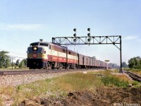 The morning CP-TH&B-NYC train from Toronto to New York speeds westbound on CN's Oakville Sub through Park Royal in the Summer of 1962, headed up by a pair of steam generator-equipped MLW FPA2 units with CP 4082 in the lead. According to schedules at the time, this would be CP train #321, departing Toronto Union Station at 8:05am and scheduled to be at TH&B's Hunter Street station in Hamilton for 9:10am. If running on time, this photo would probably be around 8:35am. CP had trackage rights over CN between Bathurst Street and Hamilton Junction, used by CP passenger trains travelling between Toronto and Hamilton, as well as freights and locals coming off the Canpa Sub. <br><br>Park Royal is located at Mile 17.6 of CN Oakville Sub. The train is approaching the level crossing at Winston Churchill Blvd., the border between Toronto Township (now Mississauga) and Oakville. Track maps show the spur to the right lead to Diversey Canada Ltd. (cleaning and food industry products). Next door further down the line was Canada Salt, who also had their own rail sidings.