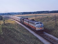 Having departed Sudbury at 11:15, CP's The Canadian is just clearing the crossing of County Road 10 as it approaches Beeton in the summer of 1962. The 12 car train is led by FP7 1401, F7B 1918, and RS10 8572 (if I'm reading the numbers correctly). The Canadian was re-routed over CN's Bala sub when VIA took over in 1978...