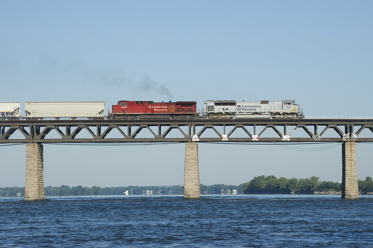 Air Force unit CP 7023 and smokey CP 8620 leads CP 253 over the St. Lawrence River on a gorgeous summer morning.