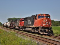 CN 5716 leads one of many delayed trains East on this very busy day. 310 the day prior had picked a switch and put a few autos on the ground just East of Trenton ( Belleville I believe ). Im guessing the switch is destined to be the replacement for whatever was damaged during the derailment. 

This day I still have written down, 38 trains on the Kingston, not including CP and Via, a personal record I will never beat. 