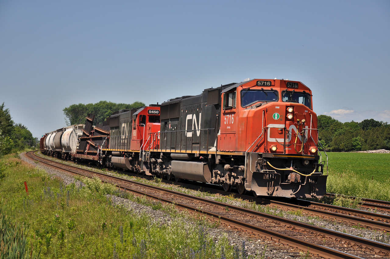 CN 5716 leads one of many delayed trains East on this very busy day. 310 the day prior had picked a switch and put a few autos on the ground just East of Trenton ( Belleville I believe ). Im guessing the switch is destined to be the replacement for whatever was damaged during the derailment. 

This day I still have written down, 38 trains on the Kingston, not including CP and Via, a personal record I will never beat.