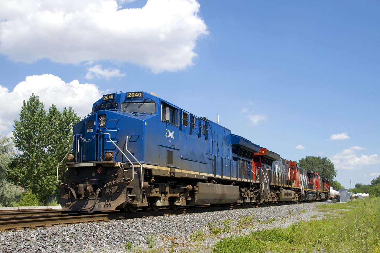 One of a handful of GECX units not repainted and renumbered by CN leads CN 527 as it crosses from the north track to the south track of CN's Montreal Sub on its way to Taschereau Yard with 49 cars. Five more units are trailing: CN 3213, CN 9454, CN 2573, CN 8819 & CN 9639.
