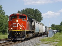 A 95-car CN 305 rounds a corner with CN 8820 up front and CN 8102 mid-train.