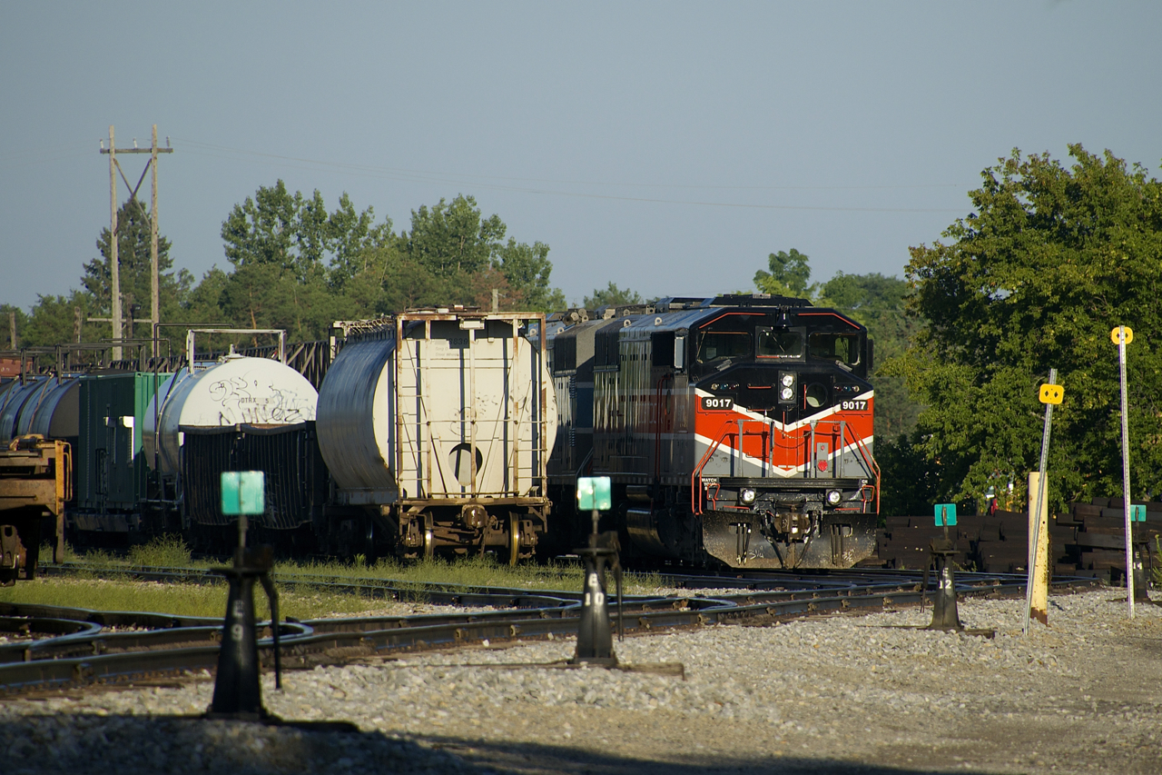 A rail train is parked in Smiths Falls Yard with CMQ 9017 & CMMQ 9011 for power. In an hour it will leave to pick up rail on CP's Winchester Sub, which is being converted from double track ABS to single track CTC.