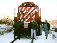 The friendly crew assigned to the last Canadian Pacific train to Guelph on the Goderich Subdivision pauses for some photos with a homemade sign in front of GP9u 1614 on the spur to the Owens Corning plant. From left to right; trainman Ray Lokun, conductor J. James and engineer Kevin Dmyterko.