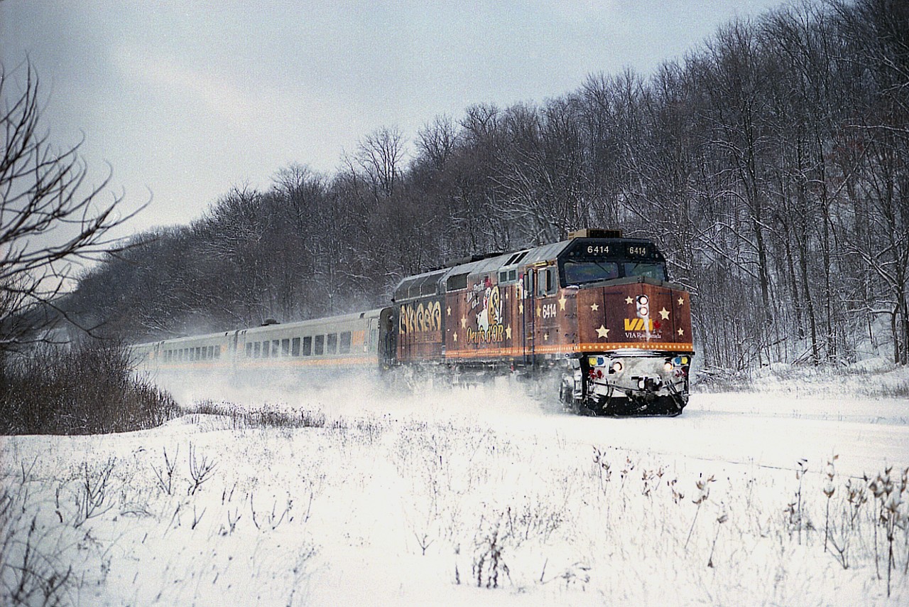 Oh, park the car and trudge thru the snow up onto the CN right-of-way in a most bleary damn cold windy day and this is what I get for a reward. The Loto Quebec paint scheme on eastbound VIA #72. This warp adorned this unit 6414 from July 2006 until at least 2011.  Yet I very seldom got to photograph it. I guess it was just as well, as I considered this wrap hideous. This was the best they could do?  Seems I am not alone in my thinking, as I  have heard this was so poorly accepted the scheme isn't even available to modellers.  At least it makes for an interesting photo as it kicks up snow on the long grade down from Copetown.
