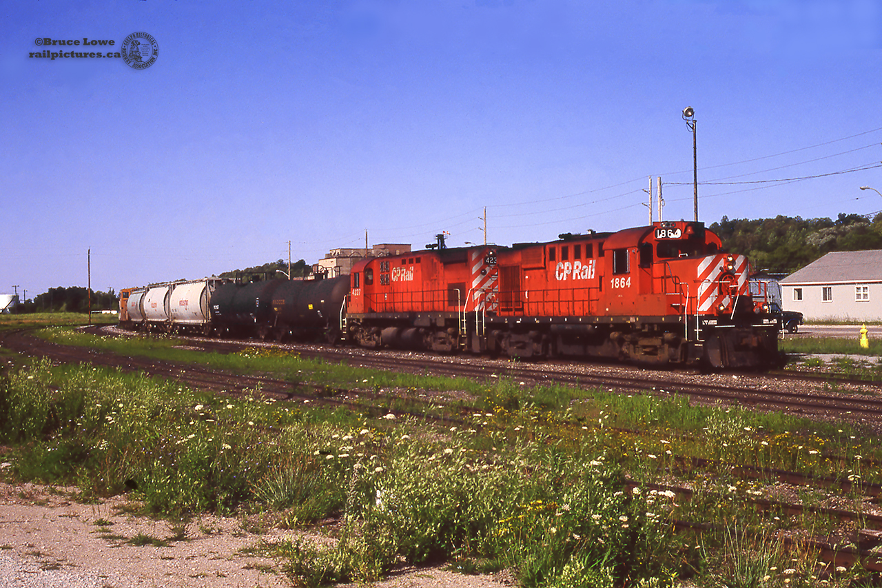 A short CP freight, led by RS18u 1864 and C-424 4237 pulls up to the Owen Sound station to drop 2 tanks and 3 Indusmin hoppers in the empty yard.  Little traffic remains on the Owen Sound sub in 1992, and in just over three years the last train will run on October 31, 1995 and the rails lifted to Orangeville shortly after.  The 1947 CPR station survives today as the Mudtown Station Restaurant.CP 1864, built as 8734 at MLW in 1957, would be rebuilt and chopped nosed in 1989 and dealt off to the New Brunswick East Coast Railway in 1998.  2003 would see the unit sent to IRSI shops in Moncton for a rebuild, emerging as Eastern Rail Services demonstrator SFEX 3000, an RS18-3a to be used on the Chemin de Fer de Lanaudière; owned by Quebec's Bell Gaz company.  The unit remains in service as CFL 3000.  CP 4237, MLW 1965, would be retired in 1997 and in 1999 was put on display at Exporail.
