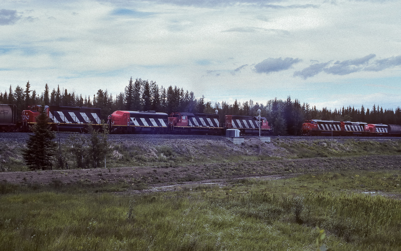 A photo not to be admired for its beauty, heavy overcast and almost 20:00, the units were in heavy shadow. Thus, a little photo work was required to bring out the subject. What is shown in the photo and I saw several times going to and from Jasper is this typical use of the F unit "beetles". With 2 trains meeting just east of Edson, both making use of these B units, all in one frame. The consist on the left is made up of 5093, 5000, 9106 and 5335. The right has the 5418, SD50F and F7Aum, (cannot make out the unit numbers).