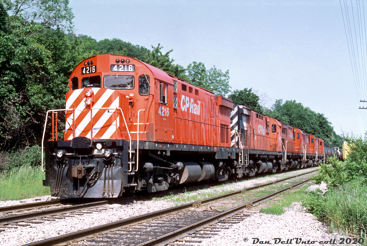 A matching set of Montreal Locomotive Works-built C424's (CP 4216 leading 4207, 4204, 4209 and 4222) sit on the head end of their train at the south end of Kinnear Yard, ready to depart down the Hamilton Sub with an acid train. Originally built in the mid 60's as road freight units and later rebuilt in the early 1980's for roadswitcher work, power-short CP kept their fleet of 4-axle C424 "Centuries" in service well into the 90's until the last few retired in 1998. I'm not sure if Bill and Reg Button were chasing this train together, but Reg managed to shoot it further down the line at both Brookfield and outside of Niagara Falls.  Bill McArthur photo, Dan Dell'Unto collection slide