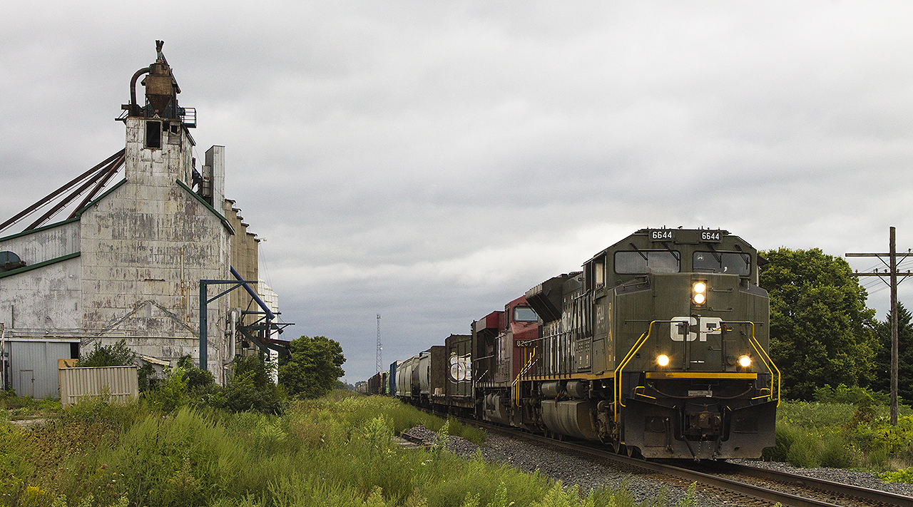 On the last weekend of  August, I found myself at one of my favourite locations. It's been made well known that these mills, which once served the railway are becoming fewer and fewer as time rolls on. Falling between Chatham and the still busy farming community of Kent Bridge, Arkwood has become a 'disarray' around this area on the Windsor Subdivision. At least that was what the owner, arriving on the scene, informed me. Words like junk', eyesore', and 'garbage'. Having said that, the weather could not have been more perfect to see 141. Just like the glory days of railroading where the siding was still in place and traffic was abundant at Arkwood, it shows how much times have changed and the possible bleak outcome that the future holds for the mill. The bright spot was that 141 was led by military unit 6644. Although having photographed this unit before, I am proud to say that despite the weather it was worth it. After all, it's not everyday that someone assumes you're with real estate company that is looking after the listing for the mill. One can only hope that under new ownership the mill will survive, to see another train.