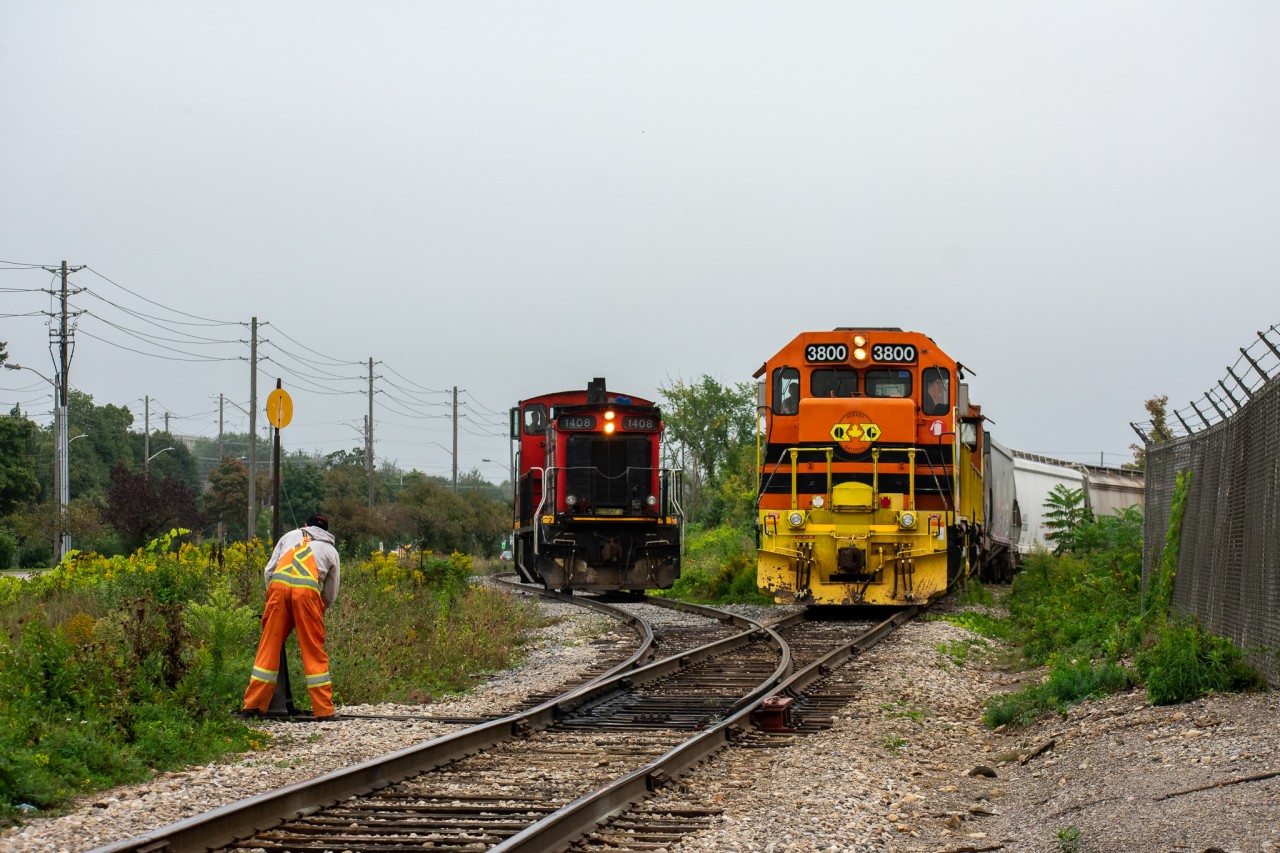 A crew member from CN 1408 is about a second away from lining a switch for his locomotive while GEXR 582 backs up to work a couple industries after their trip from Guelph Junction (Campbellville).