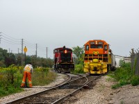 A crew member from CN 1408 is about a second away from lining a switch for his locomotive while GEXR 582 backs up to work a couple industries after their trip from Guelph Junction (Campbellville). 