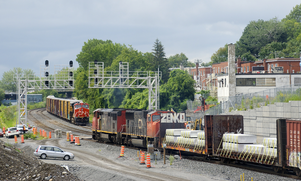Counterparts and different generations of GE products meet as CN 305 with CN 2454 leading (built in 1992) passes a parked CN 306 which has CN 3135 leading (built in 2018).