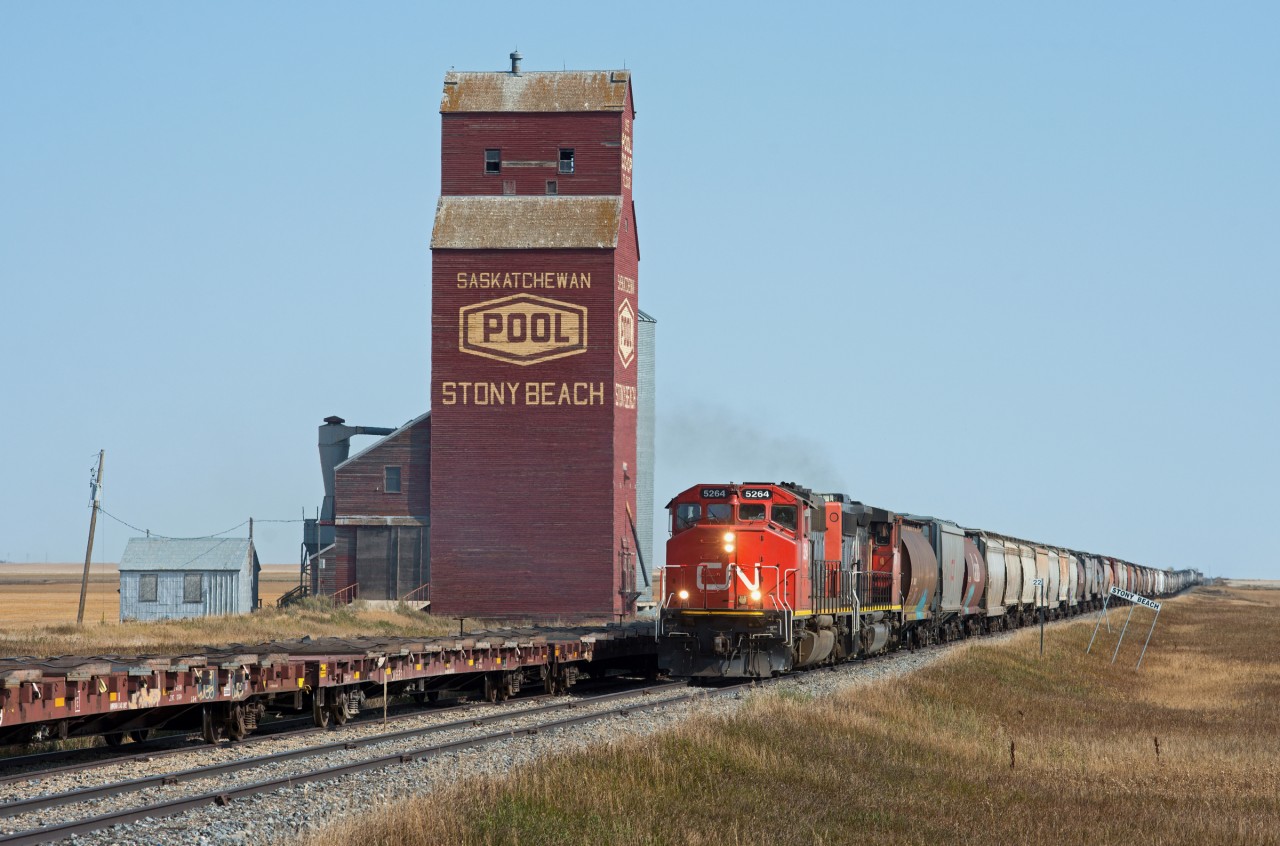 CN 556 accelerates past the picturesque elevator at Stony Beach with a fitting pair of SD40-2W's on the point and a train of empty grain cars for Moose Jaw in tow.
