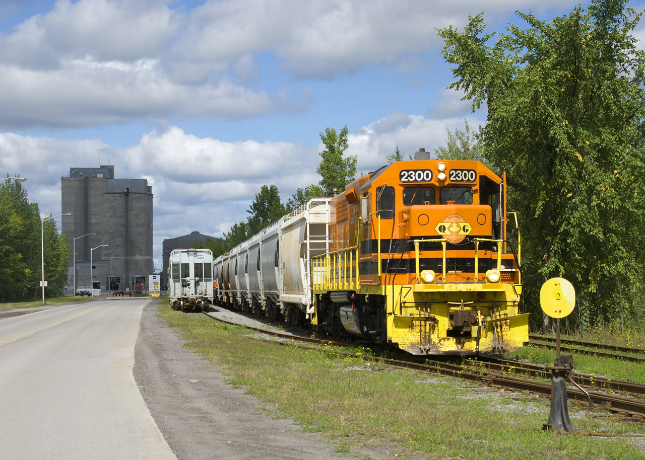 QGRY 2300 is in the process of setting off 27 hoppers at the CRH Canada Joliette Cement Plant; once that is completed it will pick up 9 hoppers and head back towards Lanoraie. This is business that the QGRY has gotten back (from CN), as this track had been out of service a number of years and was only put back into service at the start of this summer. This plant is located on the ex-CP St-Gabriel Spur, which has a number of clients in and close to Joliette. The local on this line also interchanges with CN and the chemin de fer Lanaudière (CFL).
