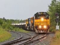 After arriving in Rouyn-Noranda, QC in a downpour, ONT 211 shoves its train of empty acid tanks and loaded copper slurry gons over the diamond with CN's Val-d'Or Subdivision. We believe these are the last operational ONR searchlights left. 