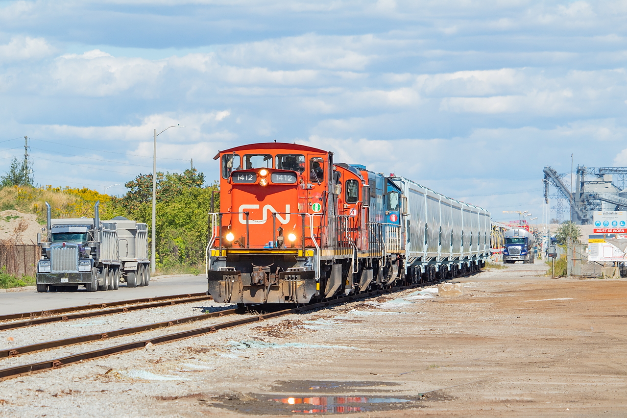 Up in the north end of Hamilton, things are bustling on a Friday afternoon. The CN 0700 Yard Job has a string of new G3 hoppers from NSC as they shove back into Parkland Terminals, to drop a few tanks to be later handled by a Cando-operated trackmobile. The dump truck at left is coming from Lafarge, and the tank truck at yet is either for Parkland or Yellowline Asphalt. There are several rail customers up on Hobson Road - Yellowline Asphalt, Crawford Rail (cars usually left on the Yellowline Lead that sometimes need to be moved out of the way to switch Yellowline), Parkland Terminals, and Lafarge (sometimes gondolas are left for them on the Rod Mill Runaround by CP, and I am told they are loaded with a black sand of sorts). Oh yeah, this one's for the crew - and sorry, I will make sure you're in the next shot. Thanks for putting up with us out there.