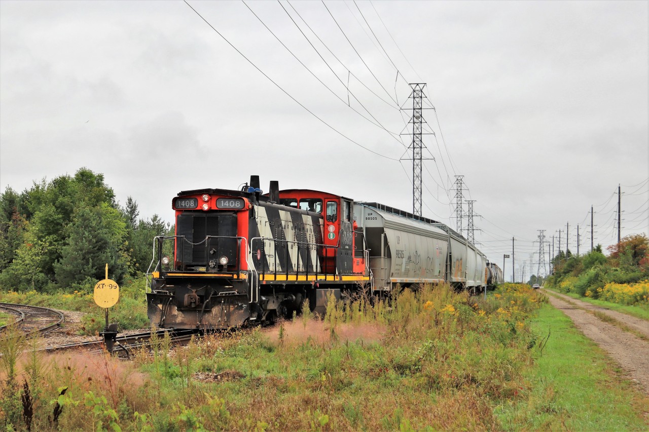 GMD1, CN 1408, backs in to the siding along Edinburgh Road in Guelph to retrieve the remainder of its load. The crew was just hoping to get the load up the hill to the yard with the single powered train in the light rain. They would then work the yard for several hours more.