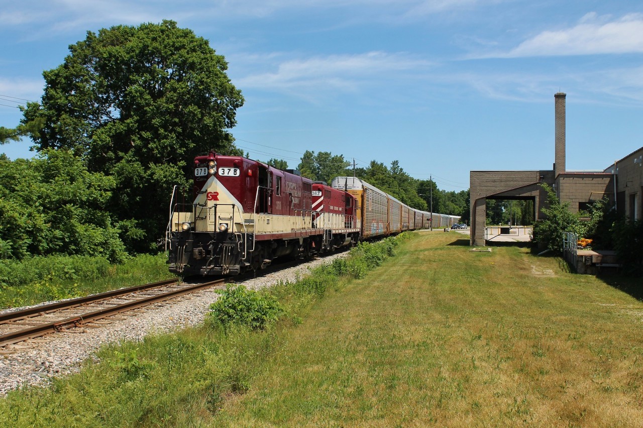 The OSR Woodstock Job passes IMT Defence in Ingersoll as they head towards the GM CAMI plant with an empty rack train.