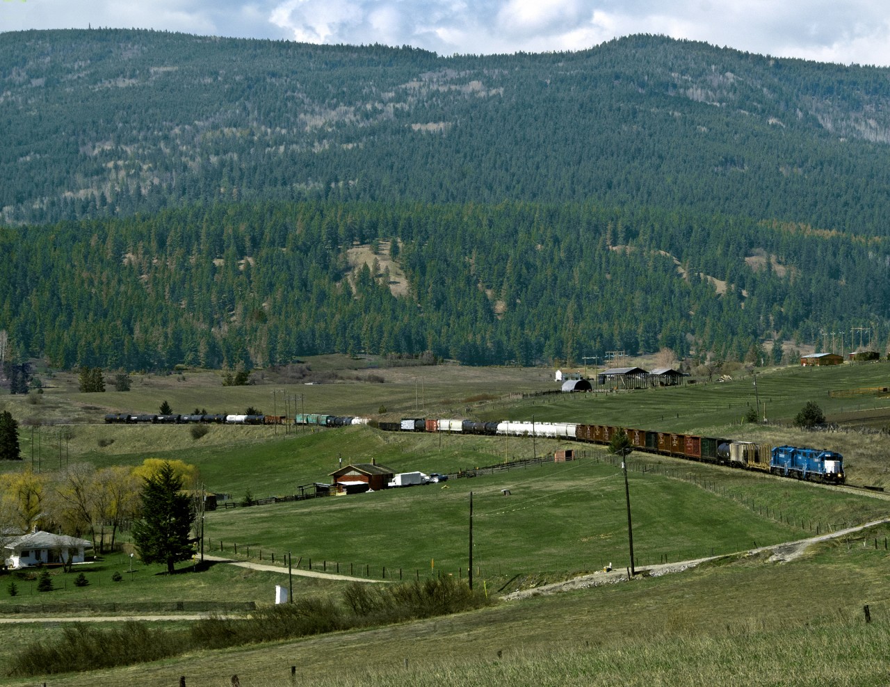 Eastbound Kelowna Pacific(a CN spinoff) Kmloops to Vernon BC freight rolls through the Grandview Valley west of Armstrong. The line was repossessed by CN a year later and the Vernon to Kelowna section was abandoned. Omnitrax's  Okanagan Valley railway (a CP Spin Off from Sicamous to Kelowna sharing the track south of Armstrong) exited operations a year earlier. Kelowna, largest city in BC's interior is now without ra1l service, but industrial Parks in the Vernon area keep the line busy for CN