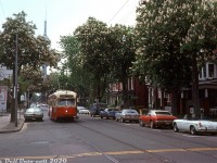 Some more 70's automotive iron for the enthusiasts: TTC A7-class PCC 4474 operates on a westbound Carlton run heading northbound up McCaul Street at Orde Street, passing by a selection of 70's automotives (can anyone ID them all?) parked streetside in front of a row of old houses (which are, unbelievably, all still present in <a href=https://www.google.com/maps/@43.6580278,-79.3930033,3a,75y,191.15h,89.73t/data=!3m6!1e1!3m4!1scLJaE_aVJggQAYrX--wSOQ!2e0!7i16384!8i8192><b>2020 Streetview imagery!</b></a>). The Carlton route PCC is possibly on a detour or short turn via Dundas & McCaul to College, where it will continue westbound to <a href=http://www.railpictures.ca/?attachment_id=31095><b>High Park Loop</b></a>. Visible in the background partially obscured by trees is the new CN Tower. Construction had largely been completed by now, but the tower itself would not yet open to the public for another year.
<br><br>
<i>Photographer unknown, Dan Dell'Unto collection slide.</i>