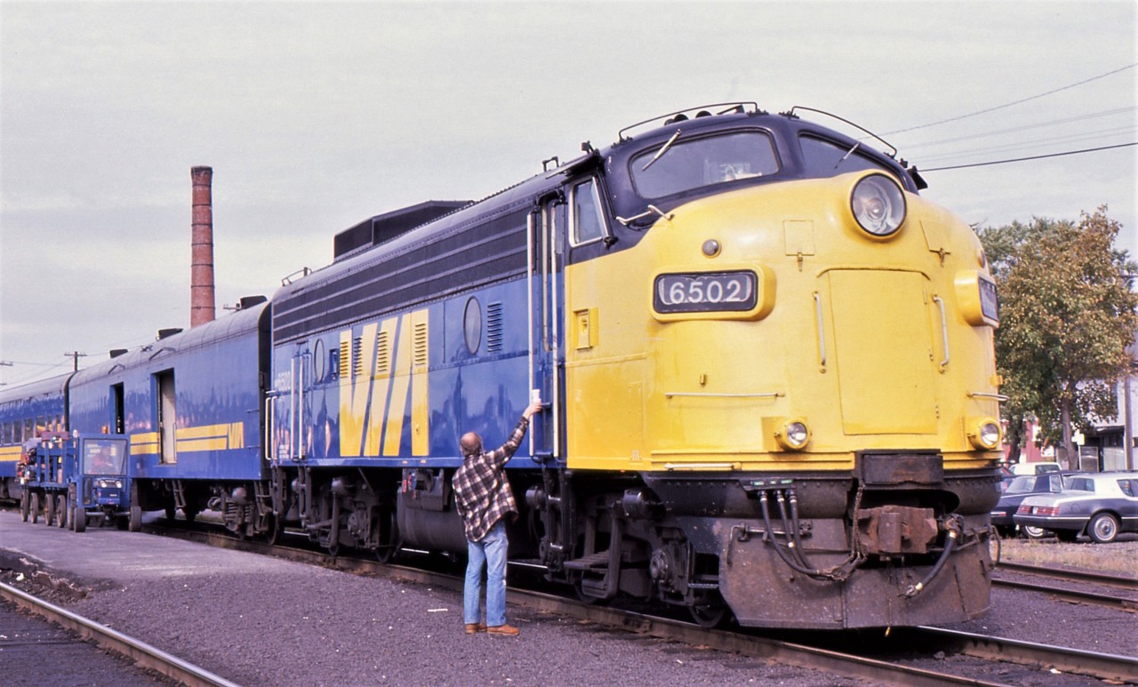 STOPPING AT SUDBURY - The fireman carries back two coffees for himself and the engineer of the 6502, about to lead the eastbound Canadian # 2 on to Montreal on September 29, 1988. The photographer and his Fiancée had traveled all the way from Winnipeg and at this stop, the train would be split into two so that this portion would head east to Montreal and the second on an adjacent track, now renamed Canadian # 10, would head due south to Toronto with them on board. Another chance to ride yet another route on their nearly month long Canadian rail adventure. Further down the line, this train would have to back up to transfer a Toronto bound passenger who accidently boarded the Montreal portion, but discovered just in the nick of time.