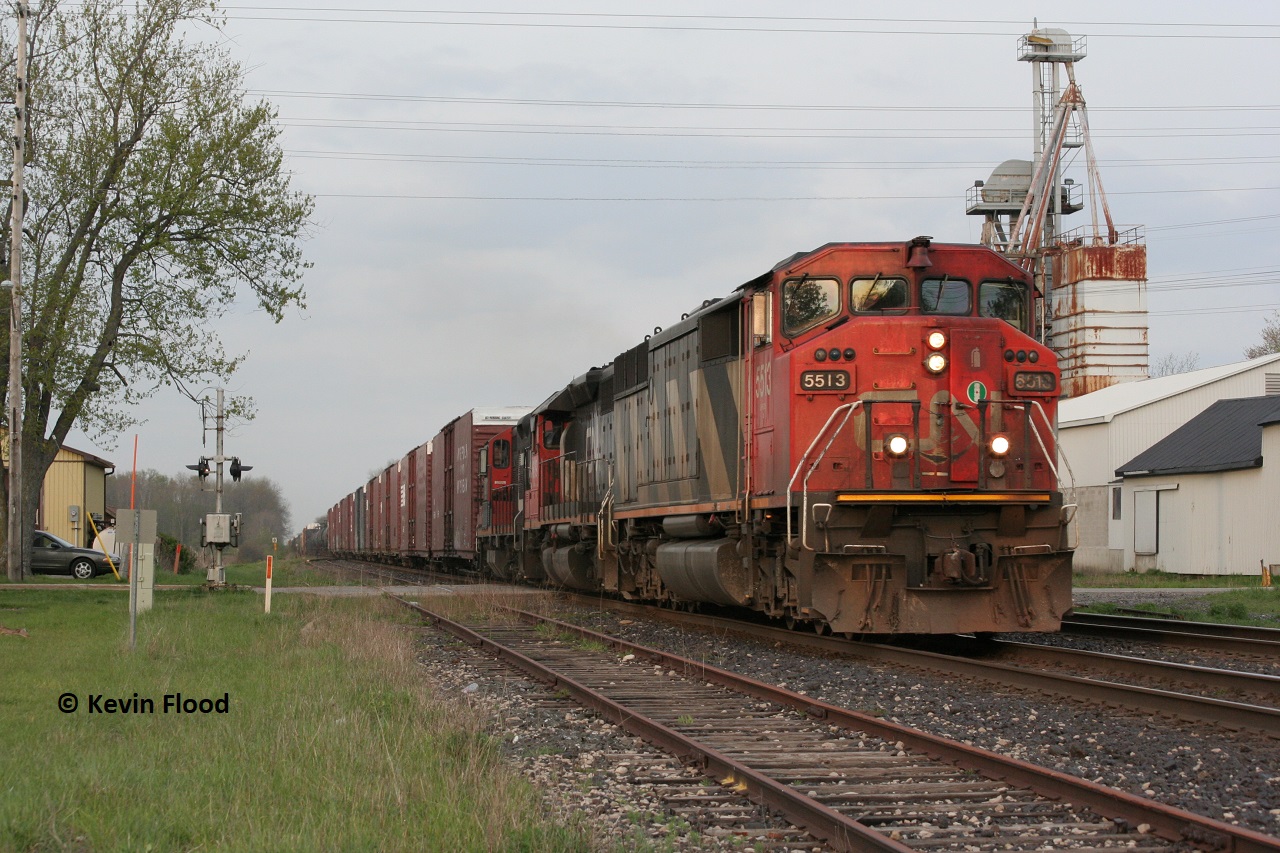 A CN westbound roars through the quiet community of Princeton, Ontario with SD50F 5513, an SD40-2, and a GP9 in the twilight hours of a spring day.