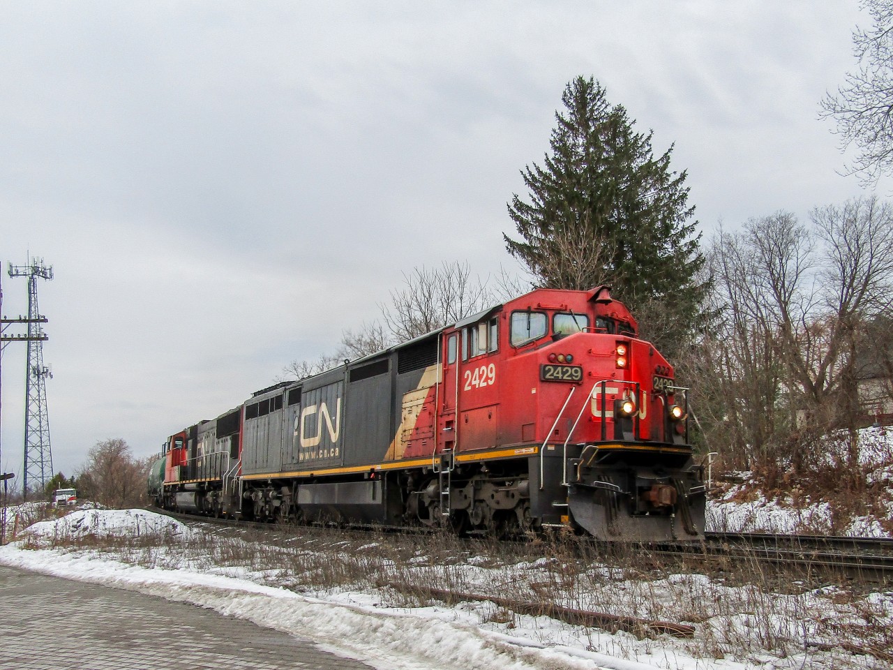 CN 303 travels north coming around the bend at Gormley ON, and is greeting with a clear on the approach to Quaker, and a very happy railfan. CN 2429 (C40-8M), CN 5611 (SD70I) make up the power for this train.
This was actually the first ever train I shot with my current camera, and this specific consist isn't catchable today, as CN 2429 is one of many C40-8M "Cowls" that have been sold for scrap. While that news, when it first broke out, was very sad, at least I have this tangible memory of 2429 riding the rails one last time.