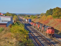 A crisp fall morning finds a Canadian-Cab dash9 on the point as 422 arrives at Aldershot with 4 stack cars on the headend for <a href=http://www.railpictures.ca/?attachment_id=39782>Q148,/a> along with it's regular lift/setoff.  The cars were part of the then new intermodal venture between CN and CSX.