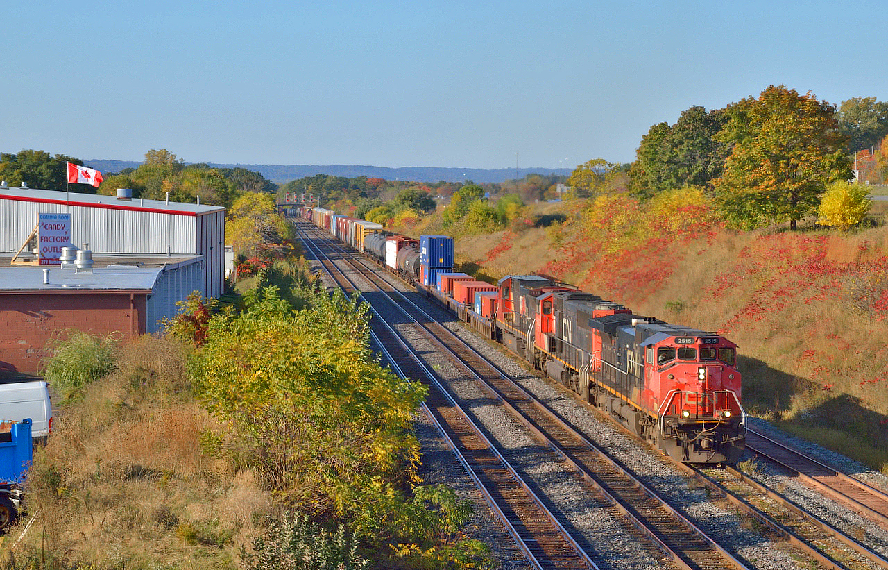 A crisp fall morning finds a Canadian-Cab dash9 on the point as 422 arrives at Aldershot with 4 stack cars on the headend for Q148,/a> along with it's regular lift/setoff.  The cars were part of the then new intermodal venture between CN and CSX.